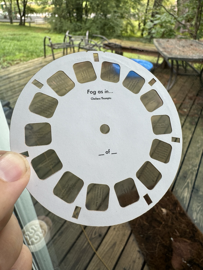 A photo of a white paper View Master disc with the words “Fog as in…” printed in the center.