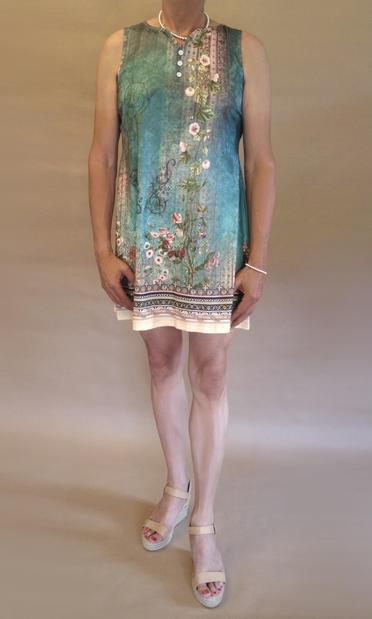 I’m wearing a blue-green and beige summer dress and beige wedge heeled sandals. Viewed from the front you can also see I’m wearing silver pearls and bright red nail polish.