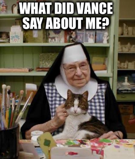 A nun in her habit with a cat in a hobby room full of crafting supplies saying "what did Vance say about me?"