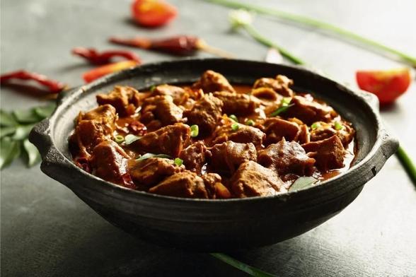 A small crock pot with lamb rogan josh.
