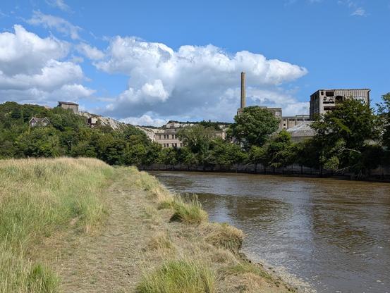 View of derelict and dilapidated cement works  buildings across the other side of the river Adur