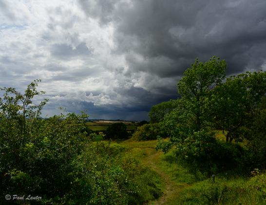 Stormy sky viewed from a public footpath over rolling hills