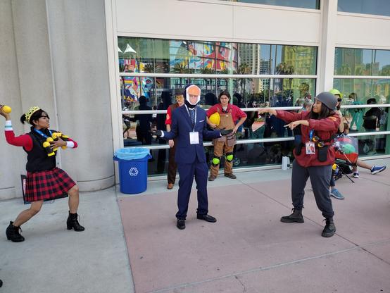 a soldier and demoman cosplayer point and and attack a spy cosplayer in an engineer mask