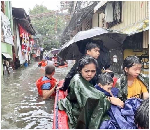 A rescue boat ferries a woman and two children on the submerged, deeply flooded streets of a barangay.