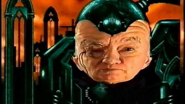 The late Sir Patrick Moore as the titular GamesMaster - a floating cybernetic head with a monocle in front of free-standing church windows against a fiery red sky. Yes, it was weird.