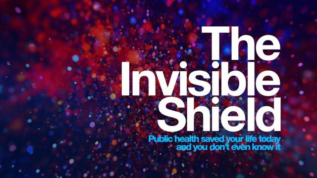 A background pattern of scattered red, indigo and violet dots exploding outward. Large bold white text says: “The Invisible Shield.” Smaller blue text says: “Public health saved your life today and you don’t even know it.”