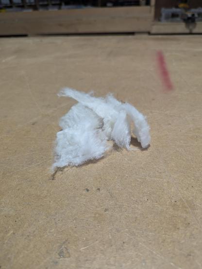 Some nitro cotton pulled apart sitting on a wood table