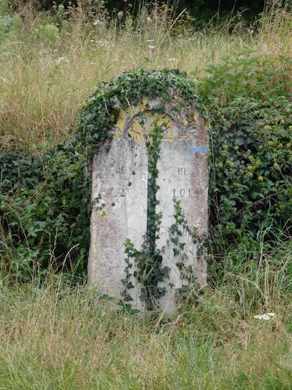 Du lierre grimpe sur une ancienne borne délimitant les territoires des départements du Lot et du Lot-et-Garonne