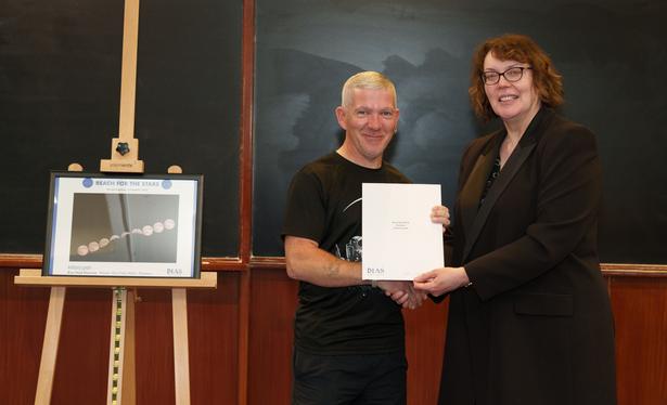 Anthony Lynch receives one of his two prizes of the night from DIAS Registrar and CEO Dr Eucharia Meehan. His image "Bray Head Moonrise" is on an easel to the left.