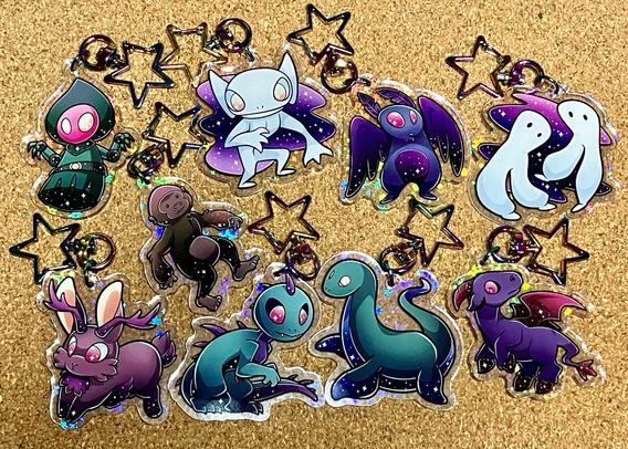 Holographic acrylic cryptid charms.