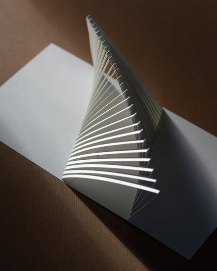 Kirigami popup de papier blanc jouant avec des lamelles créant une courbe en se décalant