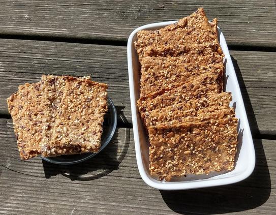 selbsgebackenes kerniges Knäckebrot
auf einer kleinen Glasschale und einer größeren weißen Keramikschale.