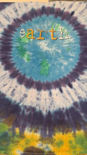Tie die T shirt, blue green center,  black and white middle orbit, yellow purple green edges.
The word 'Earth' with 'art' in contrasting colors.
