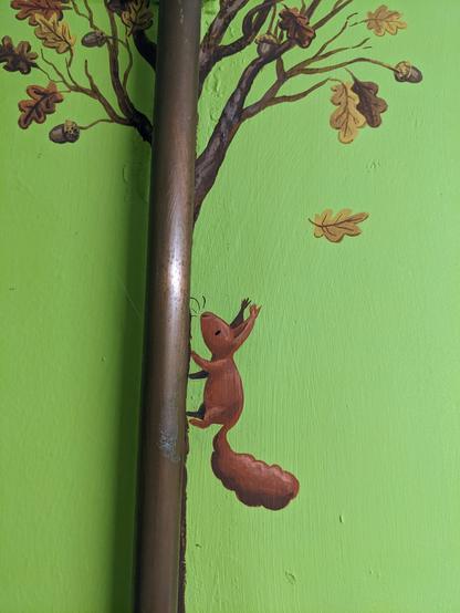 Close up of the squirrel painted in the wall. It looks like the pipe is the tree.