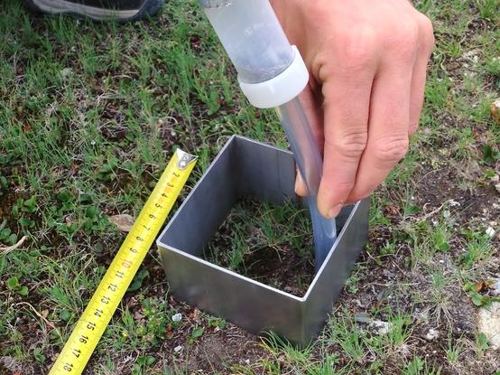 Detailed view on a suction sampling of soil mesofauna within an iron frame.
