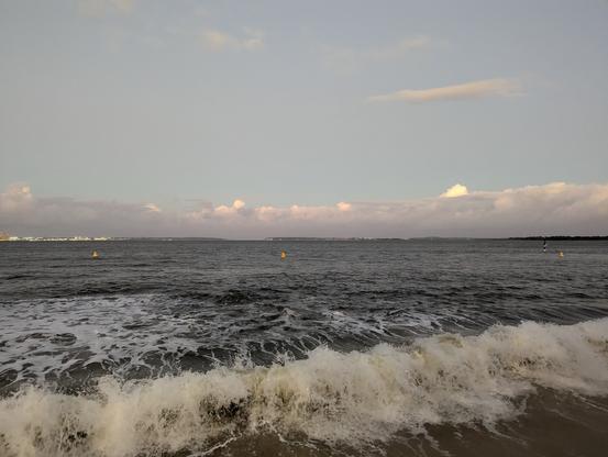 Botany bay under lightly cloudy evening sky and high tide swells washing up on the foreshore beach