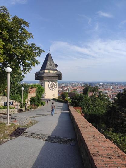 Bild vom Grazer Uhrturm. Dahinter ist die Stadt zu sehen.