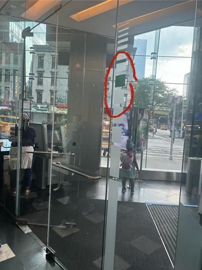 The exit from a bank is pictured, showing the discreet height measuring device on both sides of the doorways (the green square shows someone six feet tall).