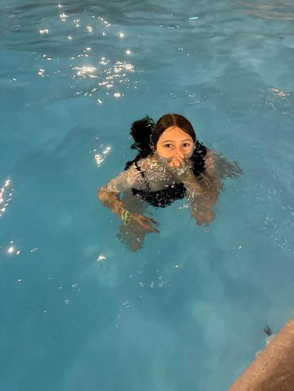Child wearing a black swimsuit in a pool