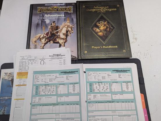 Forgotten Realms and AD&D 2nd Edition books and a bunch of character sheets.