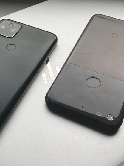 Defunct or nearly-defunct devices: Pixel 5a and Pixel 1 phones atop a 2017-vintage HP Spectre x360