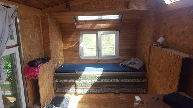 Der Bauwagen von Innen mit Blickrichtung auf ein Bett und ein Fenster