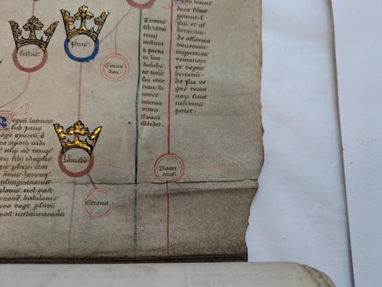 A roll of parchment with black manuscript with red and green graphic elements. Royal names are decorated with gold. The parchment membranes are re-adhered on the right side.