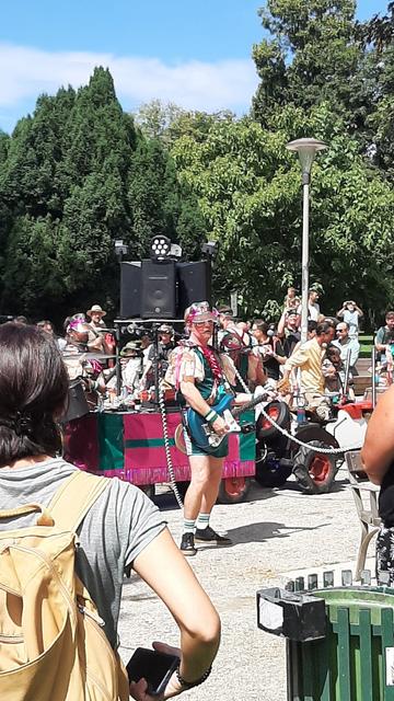 eine bunt kostümierte mobile Rockband mit Lautsprechern auf einem Bollerwagen