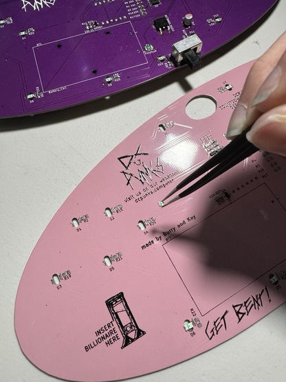 Placing LEDs onto a big pink y2k aesthetic pcb badge that will blink and countdown to year 2000