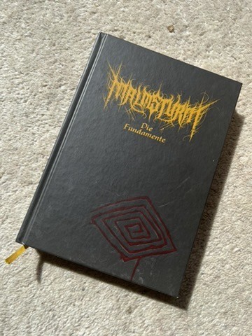 Malmsturm - Die Fundamente.

Frontcover: Nur ein tiefrote  Rune auf dunklem Hintergrund, neben dem Schritftzug und dem Untertitel.
