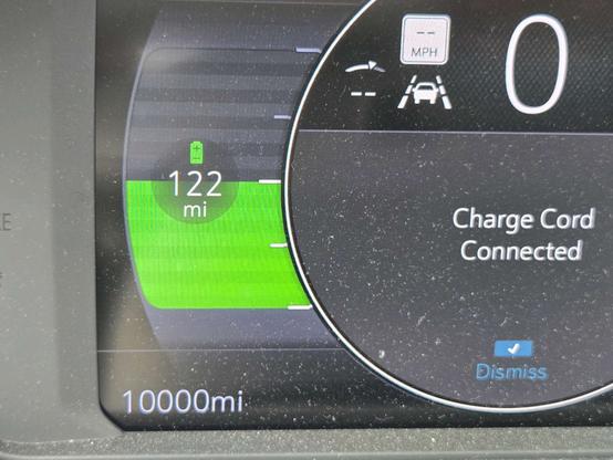 A photo of my electric vehicle's as it charges. The odometer reads exactly 10,000 miles.