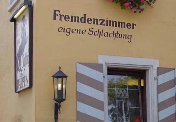 Eine Fassade mit der Aufschrift "Fremdenzimmer, eigene Schlachtung"