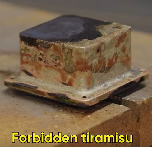 An experimental phase-changing CPU cooling block out of solid copper chunks.

It's being welded together and unpolished and partly charred, making it look like a piece of Tiramisu, stacked upon fire bricks.

There's a Subtitle saying "Forbidden Tiramisu" at the bottom