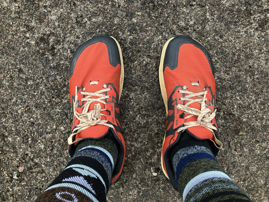 Point of view: looking down at my feet in their bright red running shoes and stripy socks.