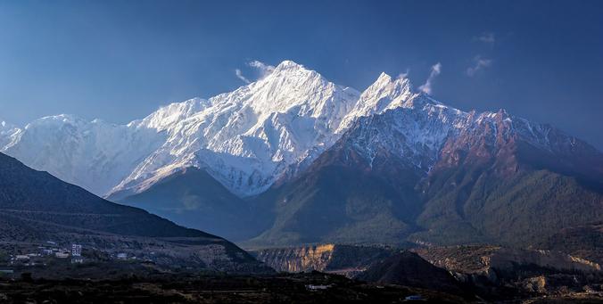 Very early in the morning, and on my first day in the Annapurna conservation area, there was this fantastic view of the massive and I guess the most prominent peak here is the Nilgiri.

The picture was taken from Jomsom. I had taken the bus to here from Pokhara, and next two weeks I would walk several parts of the Annapurna trekking. 

During this period I had a few very clear early mornings, while later clouds and haze started to obscure the mountains. But on this day I felt how it is to be in the Himalayas with its overwhelming beauty. More to follow.