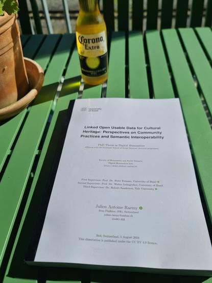Picture of a printed version of my PhD Thesis (Linked Open Usable Data for Cultural Heritage: Perspectives on Community Practices and Semantic Interoperability) on a green table - next to a bottle of beer.