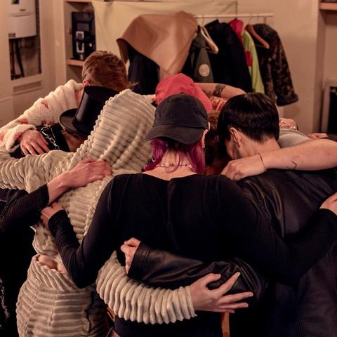 Group of people backstage huddling up