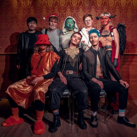 Group photo, three people sitting in front and five people standing behind them. All in costumes