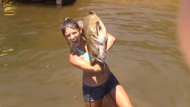 une-jeune-femme-peche-un-poisson-chat-a-mains-nues