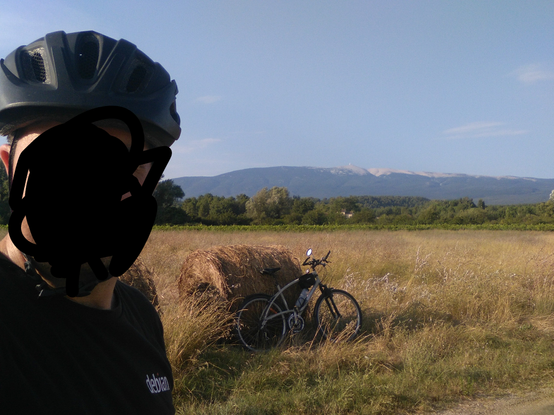 ma trogne, mon vélo appuyé sur une botte de paille et mon tee-shirt #Debian devant le Ventoux au loin