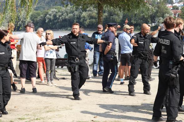 Zwei Gruppenführer versuchen eine Polizeikette zum Schutz der im Hintergrund skandierenden Rechten zu stellen.