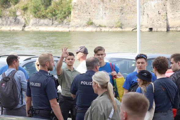 Ein Teilnehmender der aufgelösten Identitären Kundgebung mit dem White Power Symbol, rundherum Stefan R., Moritz Kirsch, Annie Hunecke, Adrian Segner und weitere