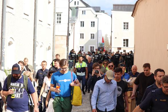 Ein Wanderkessel geleitet die Identitären von der Ortspitze und muss dabei zusätzlich von einer Polizeikette von Gegendemonstrant*innen getrennt werden
