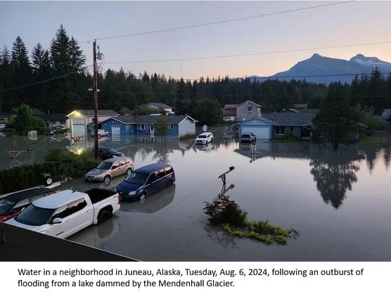 photo - water in a neighborhood in Juneau, Alaska, Tuesday, Aug. 6, 2024, following an outburst of flooding from a lake dammed by the Mendenhall Glacier.