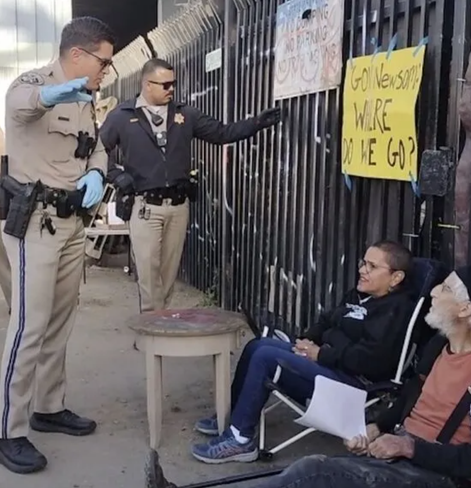 Attorney who chained herself to shipping container on state property confronted by CHP before arrest in West Oakland. Photo Courtesy: Where Do We Go