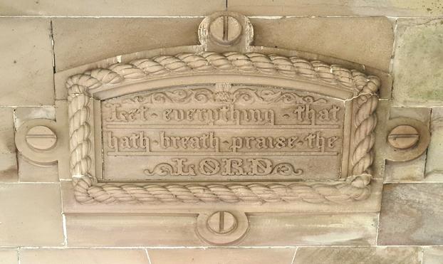 A stone plaque with fake screwhead attaching it to the wall. Two of these screw heads have the slots parallel to the ground, while on the other two, the slots are perpendicular to it. This is just plain wong!