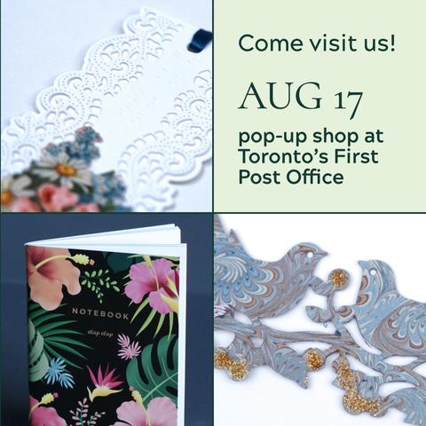 A grid of 4 images, 3 photos and 1 box of text. Text reads: Come visit us! Aug 17th. Pop-up shop at Toronto's First Post Office. A detail of a bookmark featuring blue marbled paper in the shape of birds with gold decorations. A dark blue notebook featuring wild flowers and plants. Text on top of the notebook reads: Notebook. Clap Clap. A detail of a white bookmark featuring lace-like paper and blue paper flowers.