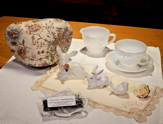 A tea tableau all in ivory & white, with lustreware china, an iridescent Fenton fawn, a delicate porcelain bunny, a small bisque bird, and a miniature ecru rose. The tea is Imperial Mao Feng.