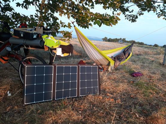 Bivouac de retour en hamac en vélo couché avec panneaux solaires préparés pour la charge du matin.