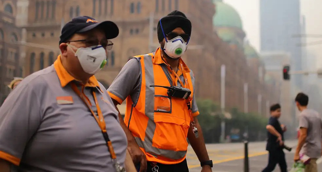 Two men in a polluted Smokey city wearing masks